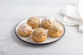 Gluten-free oat profiteroles with caramel cream of boiled condensed milk, sprinkled with powdered sugar and nuts on a