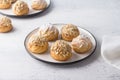 Gluten-free oat profiteroles with caramel cream of boiled condensed milk, sprinkled with powdered sugar and nuts on a