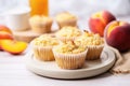 gluten-free peach muffins next to vibrant fresh peaches