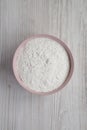 Gluten free rice flour in a pink bowl over white wooden background,  top view. Flat lay, overhead, from above Royalty Free Stock Photo