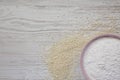 Gluten free rice flour in a pink bowl over white wooden surface, top view. Copy space Royalty Free Stock Photo