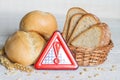 Gluten intolerance with bread wheat and warning sign on white planks Royalty Free Stock Photo