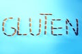 Gluten word made with pasta penne isolated on blue background