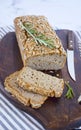 Glutenfree buckwheat bread with a golden brown crust, sprinkled with sunflower seeds, lies on a wooden table. Healthy homemade