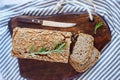 Glutenfree buckwheat bread with a golden brown crust, sprinkled with sunflower seeds, lies on a wooden table. Healthy homemade