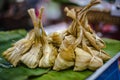 Glutinous rice mixed with sugar bean paste, wrapped in saffron leaves and steamed called Khao Tom Hang
