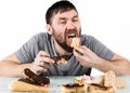 Glutton bearded man eating cupcakes with frenzy after long diet