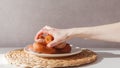 Glutton girl takes donuts from a plate one by one. Girls hand and plate with donuts