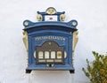 GlÃÂ¼cksburg, Germany - April 8th, 2018 - Vintage German mailbox mounted on a whitewashed wall beside a green bush Royalty Free Stock Photo