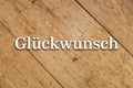 `GlÃÂ¼ckwunsch` white text on a wooden background. Translation: `Congratulations` Royalty Free Stock Photo