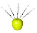 GMO food concept. Genetically modified green apple and syringes isolated. Genetic injections Royalty Free Stock Photo