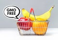 GMO free fruits in shopping basket. No GMOs used with apple, orange and banana. Consumer choice concept. Royalty Free Stock Photo