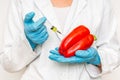 GMO scientist injecting liquid from syringe into red pepper Royalty Free Stock Photo