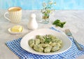 Gnocchi or dumplings with nettle or spinach on a white plate on a light gray background. Served with butter and parmesan cheese Royalty Free Stock Photo