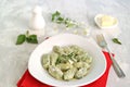 Gnocchi or dumplings with nettle or spinach on a white plate on a light gray background. Served with butter and parmesan cheese Royalty Free Stock Photo