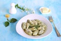 Gnocchi or dumplings with nettle or spinach on a white plate on a light gray background. Served with butter and parmesan cheese Royalty Free Stock Photo