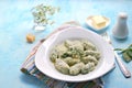 Gnocchi or dumplings with nettle or spinach on a white plate on a light gray background. Served with butter and parmesan cheese Royalty Free Stock Photo