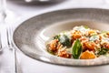 Gnocchi pomodoro with mascarpone, cream, basil and parmesan, in a stylish plate on a restaurant table