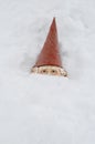 Gnome with red hat peeking out of snow