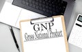 GNP word on clipboard on laptop with calculator and pen Royalty Free Stock Photo