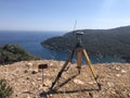 GNSS base receiver stands on the tripod at the hill top against sea at the background Royalty Free Stock Photo