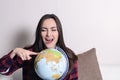 Go on an adventure. Fun woman dreaming about traveling around the world, spinning a globe and pointing at random country. Happy cu