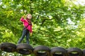 Go Ape Adventure. Toddler climbing in a rope playground structure. Cute child in climbing safety equipment in a tree