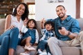 Go back to the cartoons, dad. a couple watching something on the television with their two young kids. Royalty Free Stock Photo