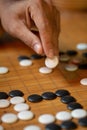 Go board game playing. A competitor is placing a marble piece on a Go board game