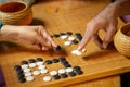 Go board game playing. A competitor is placing a marble piece on a Go board game