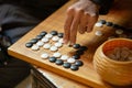 Go board game playing. A competitor is placing a marble piece on a Go board game