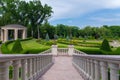 Go down to the alley of the park with crested green bushes and gazebo