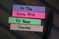 Go The Extra Mile It is Never Crowded write on sticky notes isolated on Wooden Table Royalty Free Stock Photo