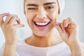 Go the extra mile for your smile. Portrait of a beautiful young woman flossing her teeth in the bathroom at home. Royalty Free Stock Photo