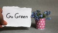 Go green concept on gray background with blue flowers