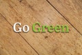 `Go green` text on a wooden background.