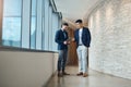 Go with this idea. two young businessmen using a digital tablet together in a modern office. Royalty Free Stock Photo