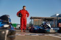 Go-kart driver walking to car before race at starting line on motor racing track Royalty Free Stock Photo