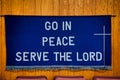 `Go in Peace Serve the Lord` written on Dark Blue Cloth hanging on the wall behind red chairs