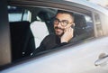 Always on the go. Portrait of a young man talking on a cellphone in a car. Royalty Free Stock Photo