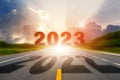 Go to the New Year 2023 concept. Number 2022 of the old year written on highway road in the middle and Number of New Year 2023 on