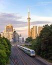 A GO Transit diesel-powered double-decker train heading to Union Station, with the CN tower in the background