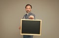 Go up to the blackboard. School teacher hold blackboard grey background. Blank blackboard for advertising information