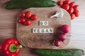 Go vegan text with fresh vegetables on table. Veganism movement concept