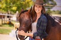 Go West young girl. Portrait of a young cowgirl standing outside with her horse. Royalty Free Stock Photo