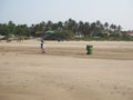 Goa, Iindia, 03.03.2020 A cleaner on the beach collects garbage.