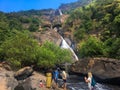 Goa, India - December 6, 2018: Beautiful view of Dudhsagar mountain waterfall. People walk near the river, admire nature and relax