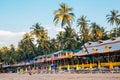 Bungalow and beach chairs and palm trees at Palolem beach in Goa, India