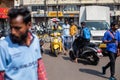 Goa, India, February 2023. Busy heavy traffic road crowded with people, motorcyclists, trucks near parking, shops.