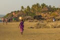 GOA, INDIA - MARCH 4: Woman in saris with basket on her head walks by Vagator beach on March 4, 2017 in Goa, India